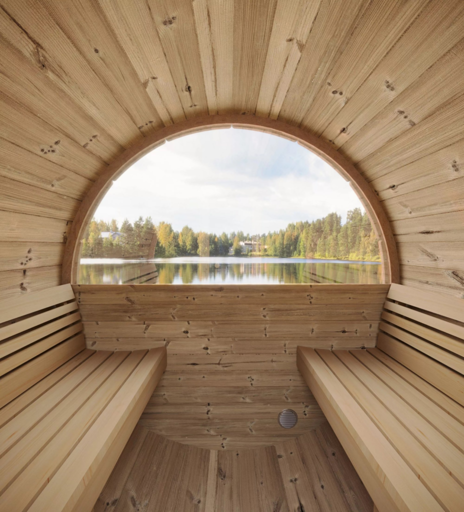 Interior de una sauna de barril con ventana al lago